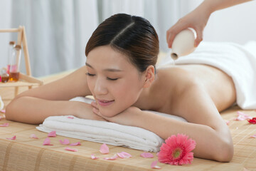 Obraz na płótnie Canvas A young women lying in bed enjoying massage