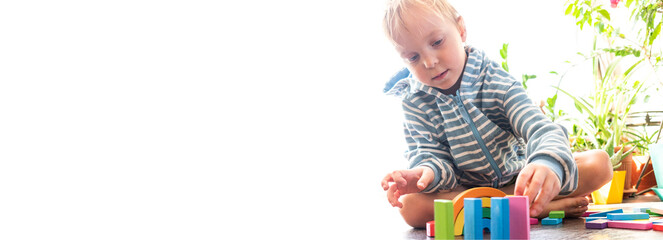 Naklejka premium Boy plays with cubes. Defocus.