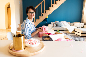 Young woman packing gift box set of natural spa kit, bath amenities for Mother's and Valentines Day