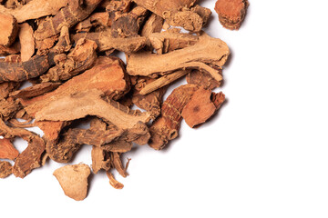 Lesser galangal, latin name Alpinia officinarum dried roots heap close-up view on white background