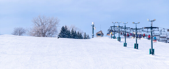 People are having fun in downhill skiing and snowboarding, panorama of ski lift
