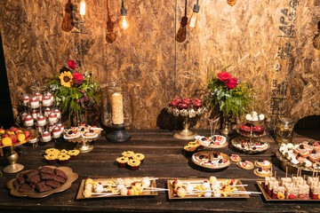 Mesa de postres en tonos cafés y dorados con luces cálidas