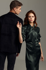 A man in a suit stands with his back to a woman in an evening dress