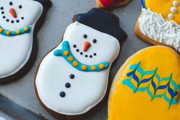 An adorable Christmas gingerbread cookie decorated to look like a happy snowman