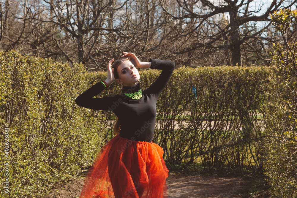 Wall mural girl in a red tutu in a city garden