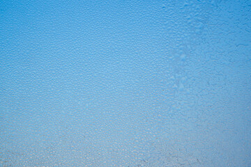 The texture of the surface of a sweaty window. Abstract blue background.