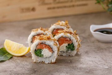 Sushi rolls with tuna shavings on a textured still life background. Restaurant concept. Close-up.