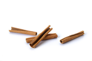 Heap of cinnamon sticks on white