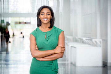African American woman in green dress in modern corporate building lobby