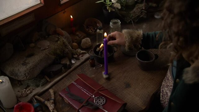 woman lighting up a candle on a misterious environment