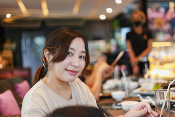 Lifestyle of happy women sitting in a restaurant decorated with soft lights on holidays