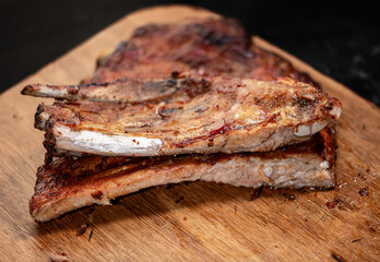 Pork ribs grilled with BBQ sauce on wooden board