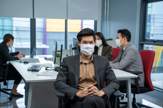 Asia Business People Wearing Protective Mask Against Airborne Disease And Salivary Infections During Outbreak Of Covid 19 Virus Working In Office.