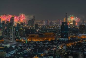 Fototapeta na wymiar Colorful Firework with cityscape night light view of Bangkok skyline at twilight time. New Year celebration fireworks light up to sky at New Year festival with Copy space. No focus, specifically.