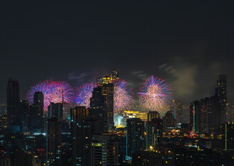 Colorful Firework with cityscape night light view of Bangkok skyline at twilight time. New Year celebration fireworks light up to sky at New Year festival with Copy space. No focus, specifically.