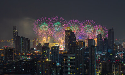 Colorful Firework with cityscape night light view of Bangkok skyline at twilight time. New Year celebration fireworks light up to sky at New Year festival with Copy space. No focus, specifically.