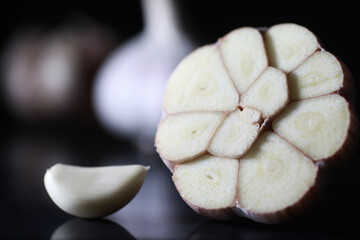 Fresh garlic clove on black background. Garlic is rich in vitamins, useful spring, good spices. Garlic sliced on a dark background. Raw sliced garlic.