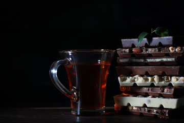 A bar of milk chocolate. Homemade milk chocolate with almonds and dried strawberries. Pieces of milk chocolate. Set of milk chocolate with tea.