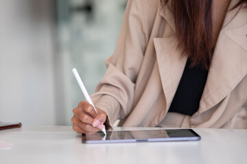 Businesswoman hand working with digital tablet with stylus pen on worktable