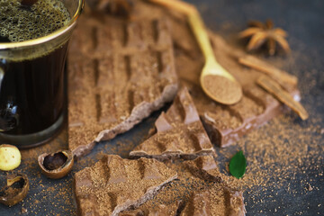 A bar of milk chocolate on the table. Chocolate with nuts and cinnamon.
