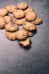 Many handmade chocolate cookies on a grey background