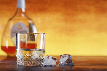 A glass of hard alcohol with ice on a bar counter. Whiskey with soda in a glass. Advertising...