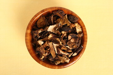 Dried mushrooms in wooden bowl. Boletus badius.