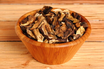 Dried mushrooms in wooden bowl. Boletus badius.