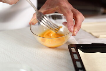 Chef beating egg with fork. Making Chicken and Egg Galette Series.