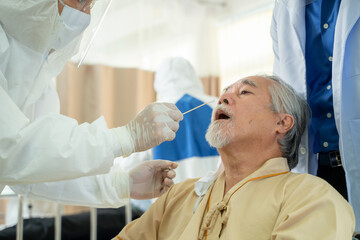 Doctor taking a throat swab for coronavirus sample from a potentially infected at...
