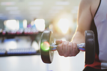 Strong arm exercising with dumbbells workout in gym,pumping up muscules with dumbbells