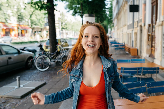 Vivacious carefree young woman laughing at camera