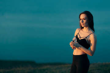 Fototapeta na wymiar Beautiful Fitness Woman with Yoga Mat Holding Water Bottle