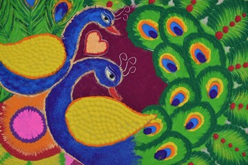 Fototapeta premium top view of designer colorful peacock rangoli design on tile during diwali