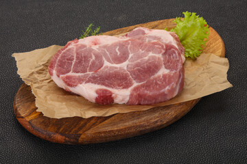 Raw pork steak over wooden board