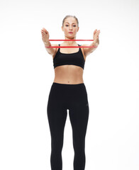 Fitness woman performs exercises for the muscles of the hands with resistance band.