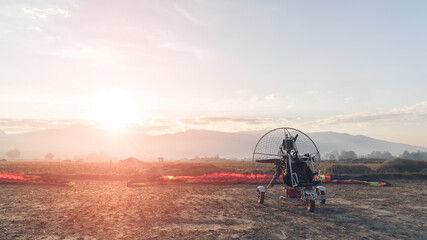 Paramotor glides in tandem prepare to fly. Paramotor pilots are preparing to fly.