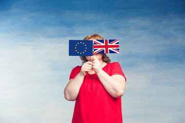 A plump young woman covered her face with the flags of the USA and the European Union.