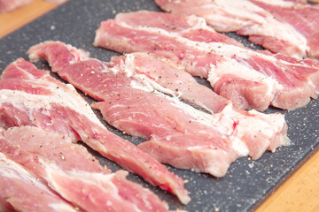 Sliced pieces of meat, on a board, pork. Close-up .