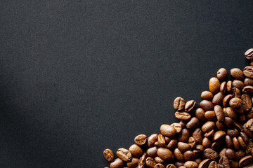 Roasted coffee beans on black paper background 