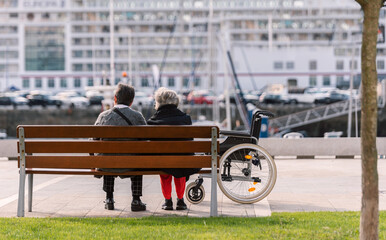 

Unrecognizable daughter sitting on bench on pier with her elderly mother in a wheelchair

Unrecognizable daughter sitting on bench on pier with her elderly mother wearing face mask