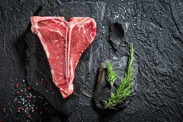 Raw red t-bone steak with salt and rosemary