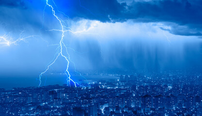 Lightning thunderstorm flash over the city at blue night sky - Lightning storm over city in blue...