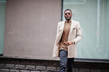 Obraz premium Stylish african american man wear beige jacket with sunglasses.