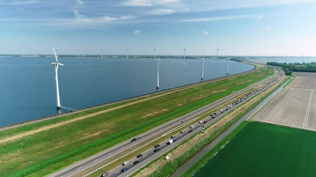 Traffic Jam with Wind Turbines on the Other Side of a Levee - Flevoland, The Netherlands, 4K Drone Footage