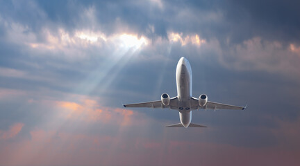 Fototapeta na wymiar Airplane flying over tropical sea at beautiful light sunset or dramatic sky 
