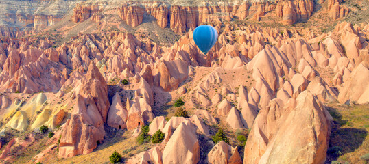 Blue hot air balloon flying over spectacular Cappadocia - Goreme, Turkey