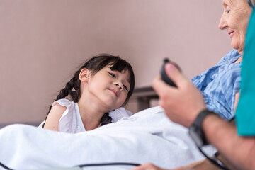 Fototapeta premium Asian Lovely girl visit and encourage grandmother on patient bed in hospital