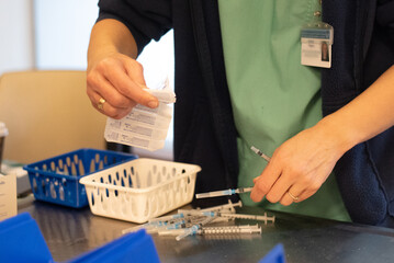 Hands of nurse prepares to vaccinate older people. On the table are disposable syringes and containers with  injection against coronavirus. In world make injections for people. vaccine for safe life