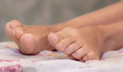 Girl's bare feet on the bed.